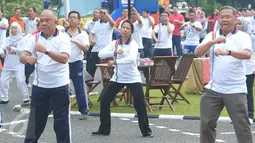 Semangatnya menteri BUMN Rini Soemarno mengikuti senam ceria bersama ratusan pegawai di Kantor Perum Bulog, Jakarta, Jumat (2/9). Senam bersama ini mengawali kegiatan kampanye daging kerbau sebagai pengganti daging sapi. (Liputan6.com/Angga Yuniar)