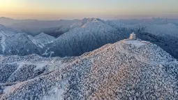 Pemandangan objek wisata Longtoushan saat matahari terbit di Distrik Nanzheng di Hanzhong, Provinsi Shaanxi, China barat laut yang terlihat dari foto udara pada 20 Desember 2020. Warna putih mendominasi pemandangan di musim dingin. (Xinhua/Tao Ming)