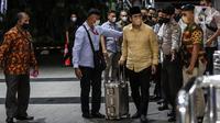 Bupati Bangkalan Abdul Latif Amin Imron membawa koper dan dikawal saat tiba di Gedung Komisi Pemberantasan Korupsi (KPK), Jakarta, Rabu (7/12/2022). KPK menangkap Bupati Bangkalan Abdul Latif Amin Imron sebagai tersangka kasus suap lelang jabatan di Pemerintahan Kabupaten Bangkalan, Jawa Timur. Total kekayaan yang dimiliki Abdul Latif sebanyak Rp 9,9 miliar. (Liputan6.com/Johan Tallo)