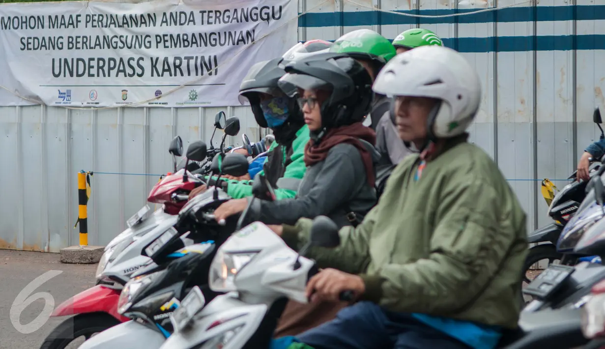 Pengedara melintas dekat spanduk pemberitahuan proyek underpass di Jalan RA Kartini, Metro Pondok, Lebak Bulus, Jakarta, Rabu (22/3). Pembangunan underpass ini untuk mengurai kemacetan di perempatan Lebak Bulus (Liputan6.com/Gempur M Surya)