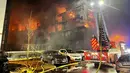 Petugas pemadam kebakaran memadamkan api di kompleks apartemen di Essen Jerman, Senin (21/2/2022). Sedikitnya tiga orang terluka dalam kebakaran besar di kompleks apartemen itu. (Christoph Reichwein/dpa vi aAP)