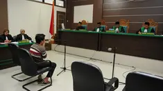 Salah seorang terdakwa pasangan sejenis (gay) di Aceh saat menghadiri persidangannya di pengadilan syariah di Banda Aceh (17/5). Majelis hakim Mahkamah Syar'iyah Banda Aceh memvonis terdakwa dengan 85 kali cambuk. (AFP/Chaideer Mahyuddin)