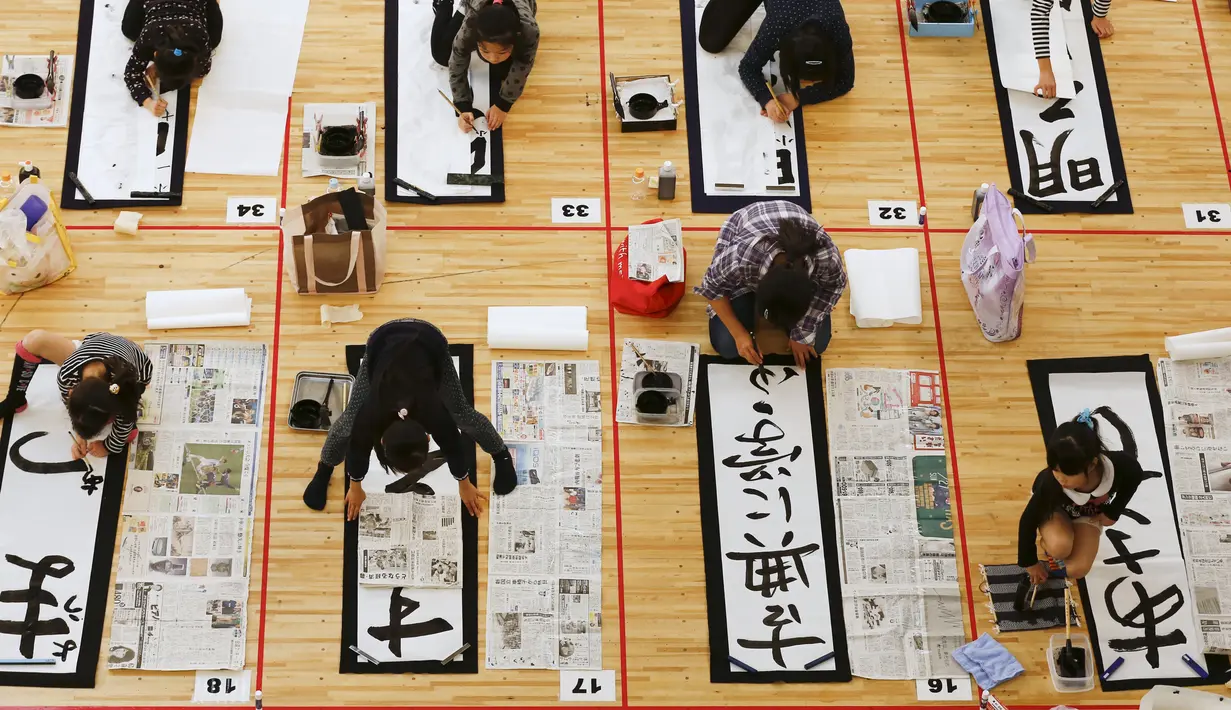 Sejumlah peserta menulis kaligrafi saat mengikuti kontes kaligrafi dalam merayakan tahun baru di Tokyo, Jepang, Selasa (5/1/2016). Lebih dari 3000 peserta menuliskan resolusi tahun baru di atas sebuah kanvas. (REUTERS / Thomas Peter)