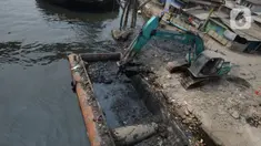 Alat berat mengangkat material endapan lumpur di Kampung Nelayan Cilincing, Jakarta Utara, Kamis (2/9/2021). Pengerukan dilakukan untuk mengurangi pendangkalan di muara teluk Jakarta serta penataan sandaran kapal-kapal tradisional. (merdeka.com/Imam Buhori)