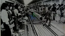Suasanan peron Stasiun Gambir di tahun 1982 yang dipadati pemudik jurusan Solo. Pada saat itu, harga karcis kereta Gambir-Solo hanya Rp4 ribu saja. (Source: Facebook/Perpustakaan Nasional)