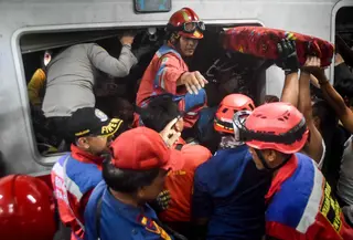 Tim pencari dan penyelamat gabungan berupaya menyelamatkan salah satu korban yang terjebak di dalam gerbong setelah lokomotif Kereta Api Jarak Jauh (KAJJ) Argo Bromo Anggrek menabrak gerbong belakang Kereta Rel Listrik (KRL) Commuter Line di stasiun Bekasi Timur, Bekasi, Jawa Barat pada Selasa 28 April 2026. (Rezas/AFP)