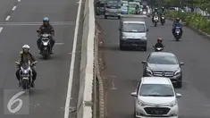 Pengendara motor melintas di Jalan Layang Non Tol Kampung Melayu arah Tanah Abang, Jakarta, Senin (9/1). Minimnya pengawasan membuat pemotor dapat leluasa memasuki jalur khusus roda empat atau lebih tersebut. (Liputan6.com/Immanuel Antonius)
