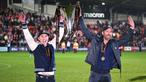Aktor Hollywood, Ryan Reynolds (kanan) dan pemilik klub Wrexham, Rob McElhenney merayakan kesuksesan dengan mengangkat trofi setelah klub mereka berhasil promosi ke Liga Dua Inggris. Wrexham menang atas Boreham Wood dengan skor 3-1 pada laga English National League di Racecourse Ground Stadium, Wrexham, Wales, Sabtu (22/04/2023). (AFP/Oli Scarff)