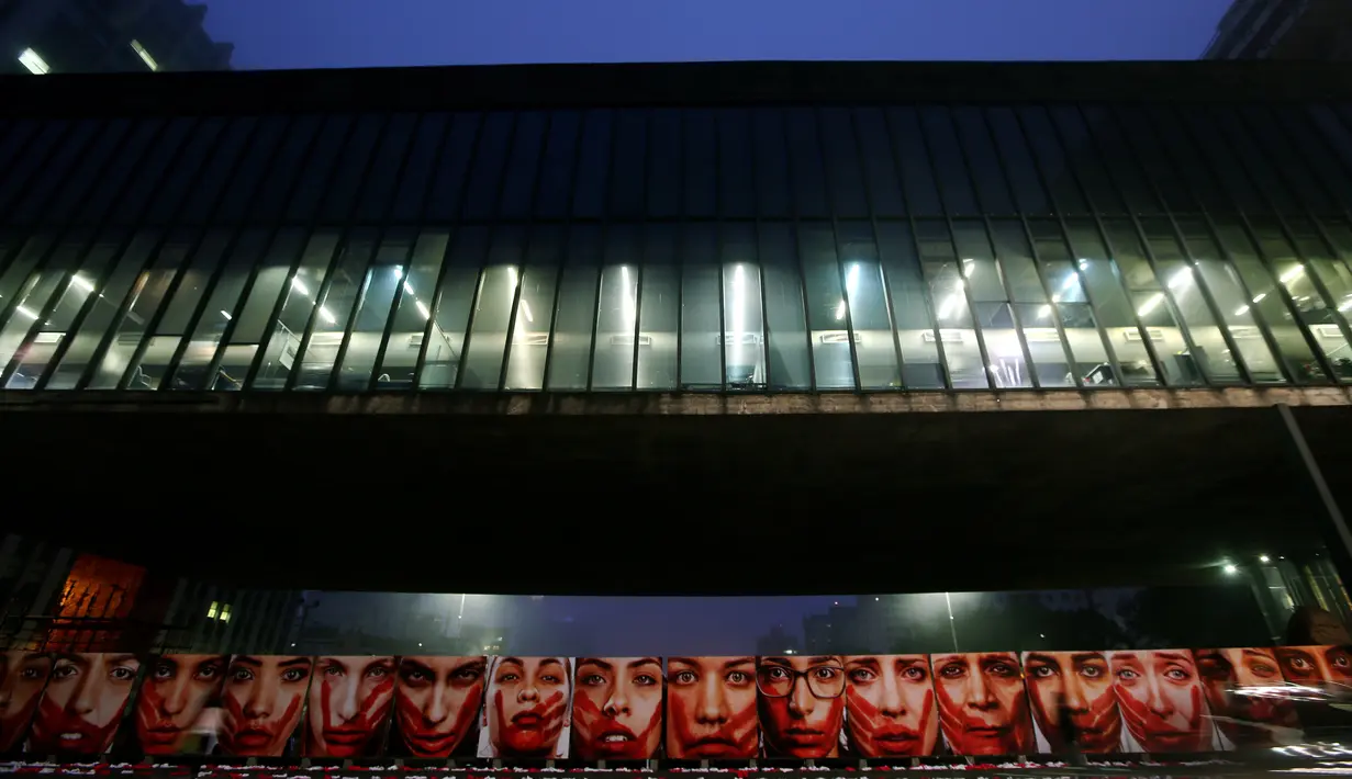 Deretan foto wanita dengan wajah bercat merah terpampang di Sao Paulo Art Museum, Brasil , 10 Juni 2016. Foto hasil jepretan fotografer Brasil Marcio Freitas ini merupakan sindiran bagi kejahatan dan kekerasan kepada perempuan. (REUTERS / Paulo Whitaker)