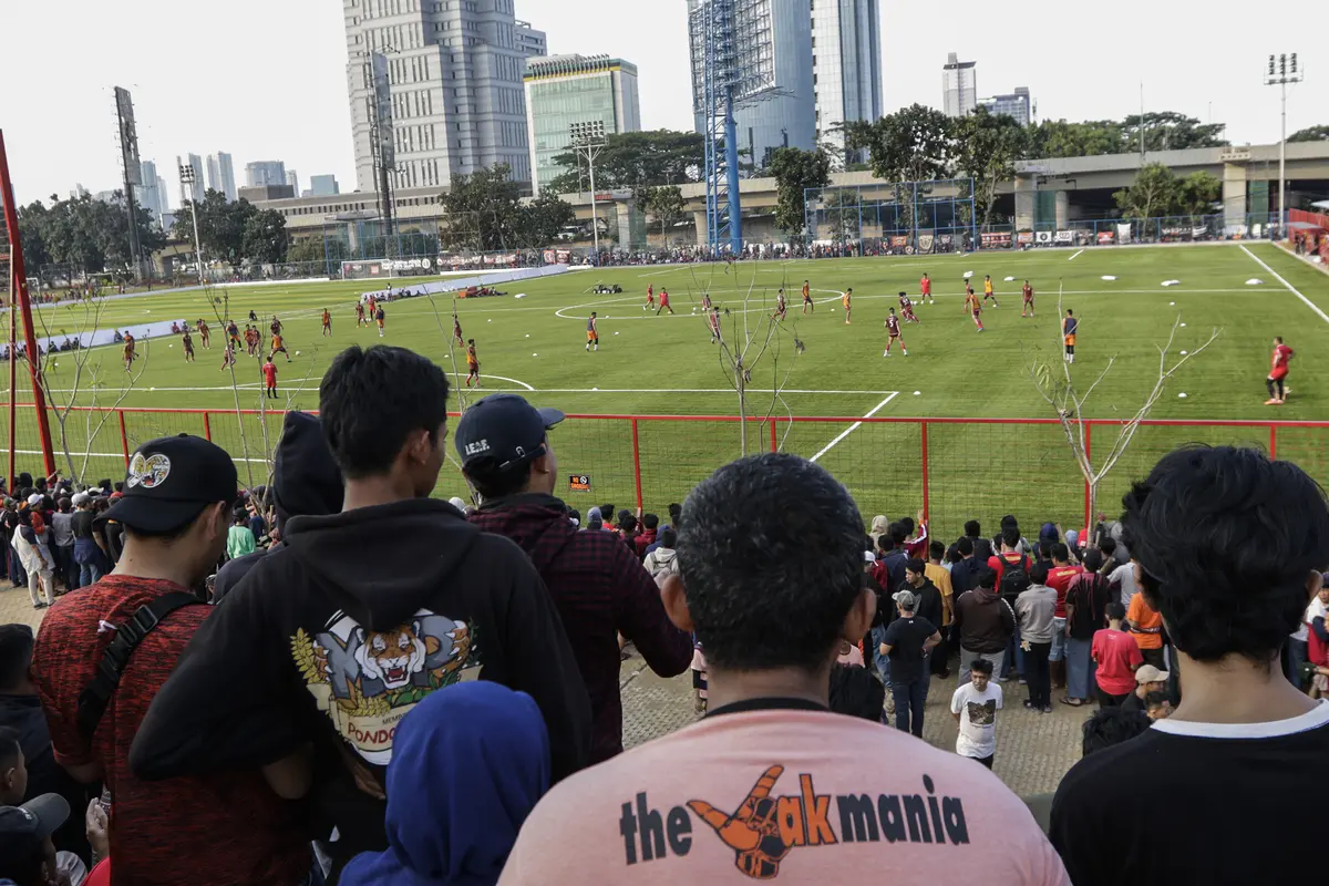 Suporter Persija Jakarta, The Jakmania, menonton latihan perdana Macan Kemayoran di Lapangan Aldiron. (Bola.com/M. Iqbal Ichsan)