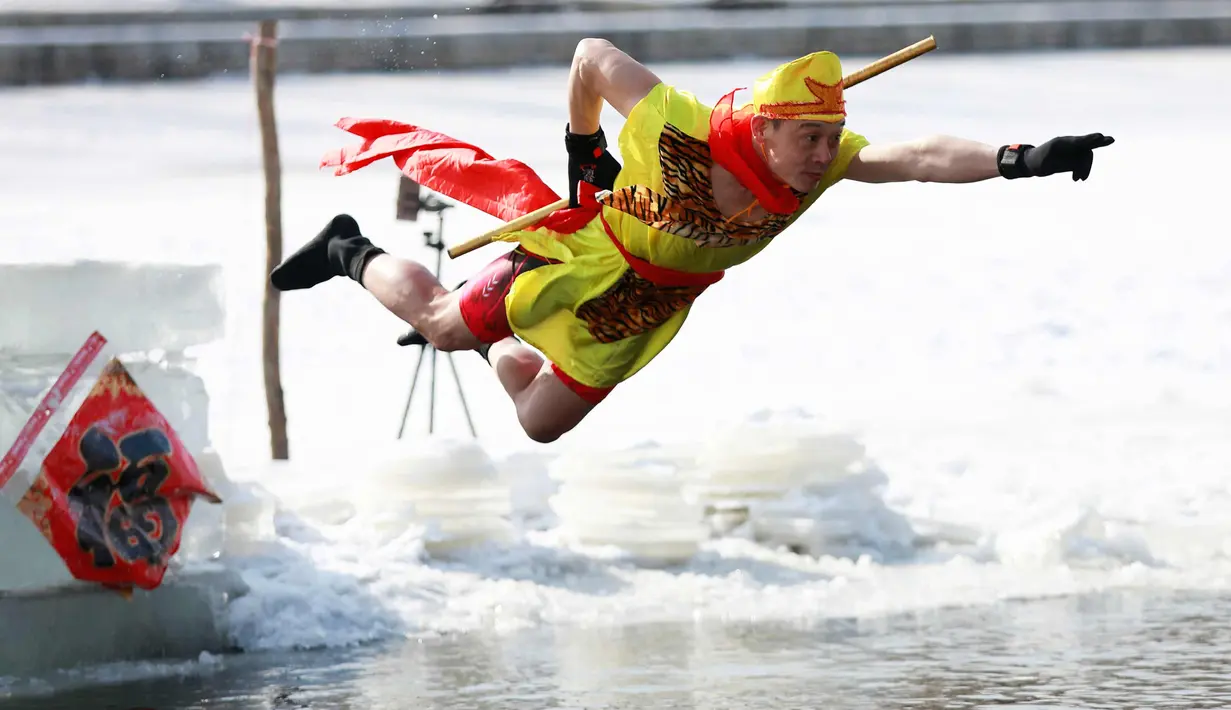 Seorang pria saat melompat ke danau yang beku di Shenyang di provinsi Liaoning, China timur laut (2/3). (AFP Photo)