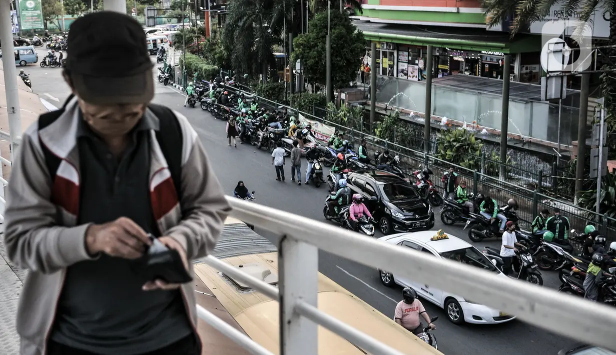 Pengemudi ojek online (ojol) memenuhi bahu jalan saat menunggu penumpang di kawasan Cililitan, Jakarta, Rabu (16/9/2020). Pemprov DKI Jakarta telah melarang ojol dan ojek pangkalan berkumpul lebih dari lima orang serta menjaga jarak sepeda motor minimal dua meter. (merdeka.com/Iqbal S. Nugroho)