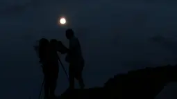 Pasangan mengambil gambar supermoon di Ischigualasto Provincial Park, San Juan, Argentina(13/11). Supermoon kali ini menjadi bulan purnama paling dekat ke bumi sejak 26 Januari 1948. (REUTERS/Enrique Marcarian)