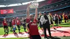 Pemain Manchester United, Sofyan Amrabat mengangkat trofi saat merayakan gelar juara Piala FA 2023/2024 di Stadion Wembley, London, Sabtu (26/05/2024). MU menang dengan skor 2-1 atas Manchester City di partai final. (AFP/Justin Tallis)
