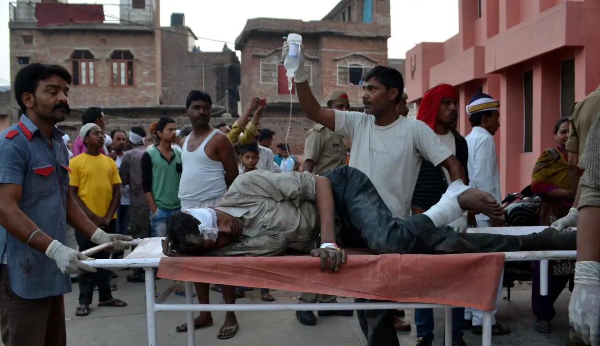 Salah satu korban kecelakaan truk yang jatuh ke sungai dibawa ke rumah sakit, Etah, India, Jumat (5/5).  Sekitar 14 orang dikabarkan meninggal dalam peristiwa tersebut. (AFP/STR)