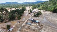 Warga berjalan di sepanjang jalan di sebuah desa yang terdampak banjir bandang di Batang Toru, Sumatera Utara, Senin 1 Desember 2025. Serangkaian bencana hidrometeorologi, yang mencakup banjir bandang (flash floods) dan tanah longsor dalam skala masif, menghantam beberapa wilayah di tiga provinsi di pulau Sumatera. (AP Photo/Binsar Bakkara)