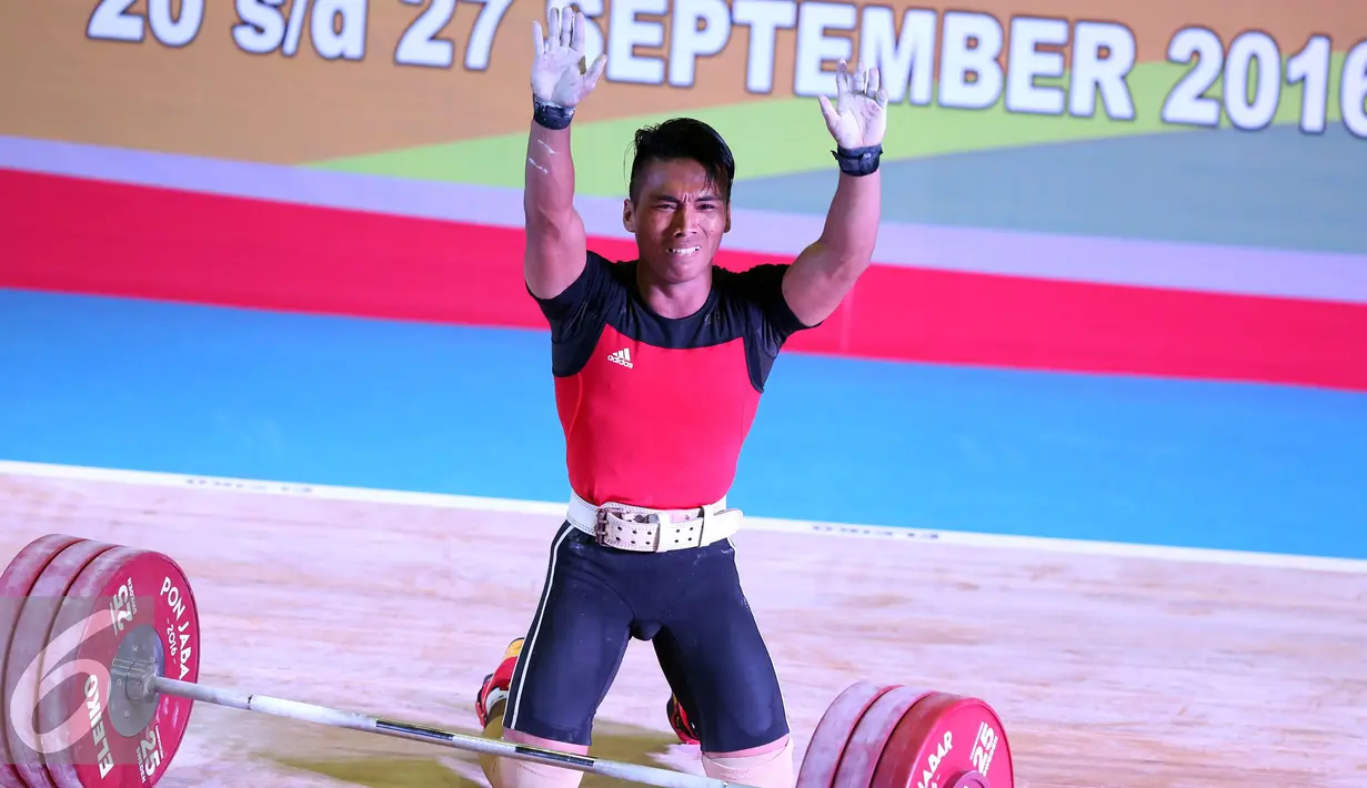 Lifter Jawa Barat, Deni melambaikan tangan usai mengangkat beban 183kg clean and jerk kelas 69kg PON XIX Jabar di Gymnasium Si Jalak Harupat, Kab Bandung, Rabu (21/9). Deni meraih emas dengan total angkatan 328kg. (Liputan6.com/Helmi Fithriansyah)