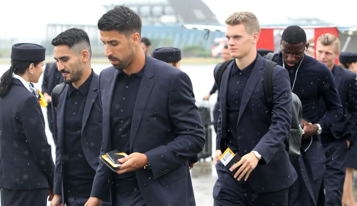 Pemain Jerman, Sami Khedira dan Ilkay Gundogan berdiskusi saat tiba di Moskow, Selasa (12/6/2018). Jerman datang ke Rusia untuk mempertahankan gelar juara Piala Dunia. (AFP/Daniel Roland)