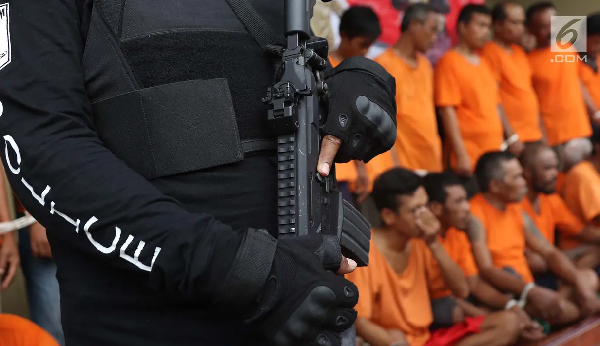 Polisi berjaga saat rilis kasus premanisme di Mapolres Metro Jakarta Barat, Senin (12/11). Polisi menangkap 23 pria dari dua kasus berbeda karena  tindakan perusakan, intimidasi, pengusiran, dan penguasaan lahan di Jakbar. (Liputan6.com/Immanuel Antonius)