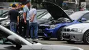 Peserta Drift Clinic melihat kondisi mesin salah satu mobil di Jakarta, Sabtu (1/12). Dalam kesempatan itu, komunitas BMW M Owners Club Indonesia (MOCI) mengelar acara pelatihan Drift Clinic teknik keselamatan. (Merdeka.com/Dwi Narwoko)