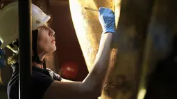 Para ahli restorasi Museum Vatikan bekerja untuk menghilangkan kotoran yang telah berabad-abad menempel pada patung perunggu terbesar di dunia kuno: patung Hercules Mastai Righetti yang disepuh emas.  (AP Photo/Andrew Medichini)