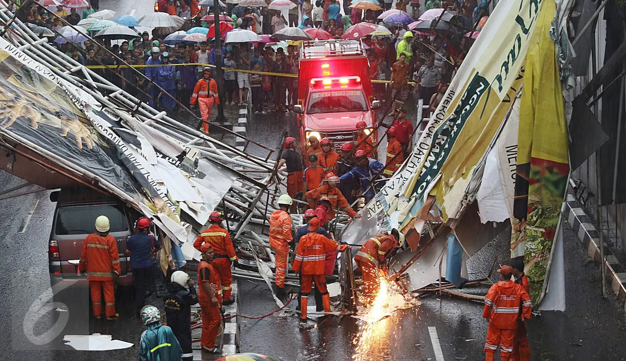 Petugas berusaha memotong bagian JPO yang roboh di Jalan Raya Pasar Minggu, Jakarta Selatan, Sabtu (24/09). Korban meninggal akibat JPO roboh dibawa ke RS Siaga Pasar Minggu. (Liputan6.com/Immanuel Antonius)