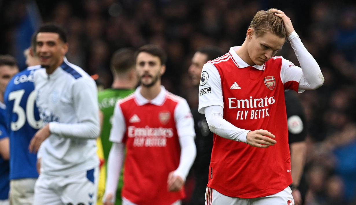 Reaksi kecewa pemain Arsenal, Martin Odegaard (kanan) setelah timnya kalah dari Everton dengan skor 0-1 pada laga pekan ke-22 Liga Inggris 2022/2023 di Goodison Park, Sabtu (04/02/2023). (AFP/Paul Ellis)