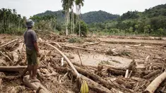 Seorang pria melihat kerusakan yang disebabkan oleh banjir yang membawa sisa-sisa pembalakan liar di Pelangai Gadang, Sumatera Barat, pada Sabtu 15 Maret 2025. (REZAN SOLEH/AFP)
