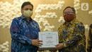 Menristek Bambang Brodjonegoro (kanan) memberikan GeNose C19 kepada Menko Bidang Perekonomian Airlangga Hartarto di Gedung Kemenko Perekonomian, Jakarta, Senin (22/3/2021). GeNose C19 diharapkan dapat semakin dikenal dan dimanfaatkan secara lebih masif. (Liputan6.com/Faizal Fanani)