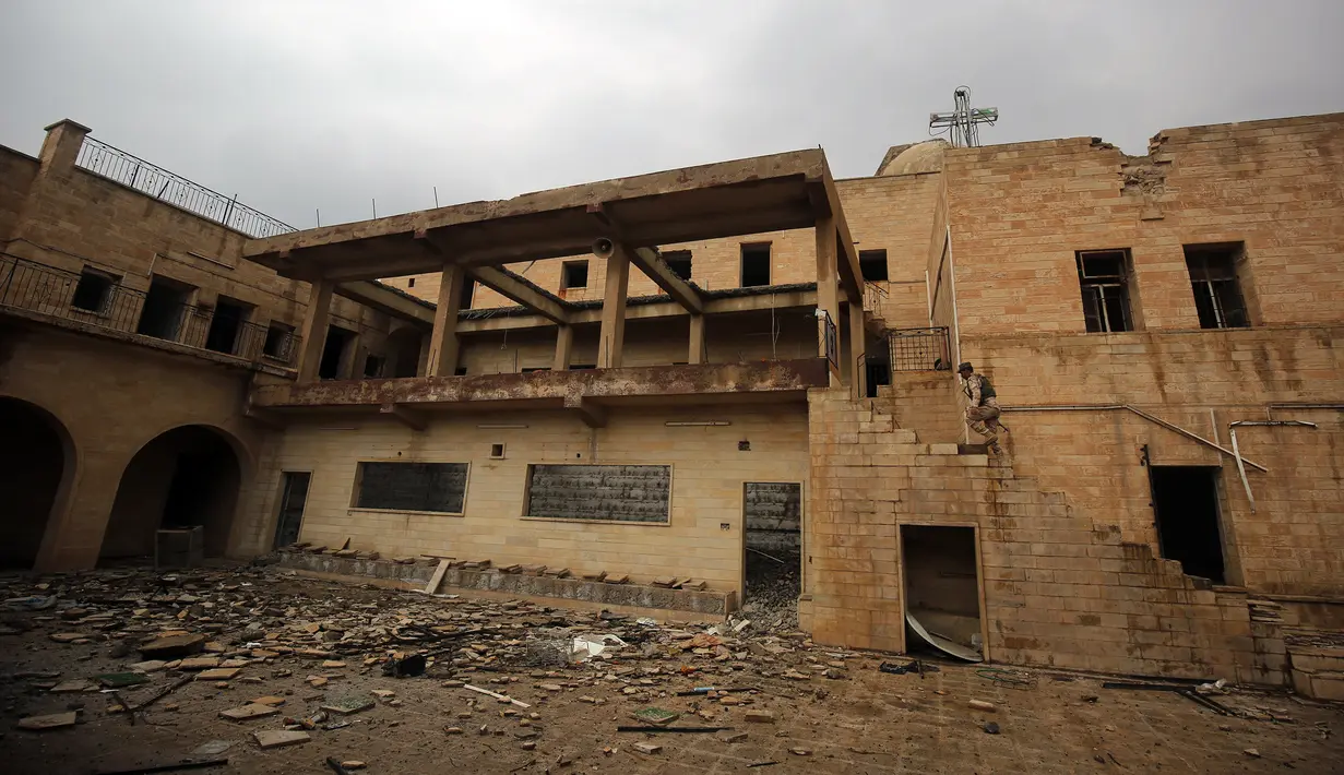Seorang tentara Irak memeriksa Gereja St. George Monastery (Mar Guguis) yang rusak parah di Mosul, 22 Januari 2017. Salah satu gereja bersejarah di Irak tersebut tak luput dari pengerusakan yang dilakukan kelompok radikal ISIS. (AHMAD AL-RUBAYE/AFP)