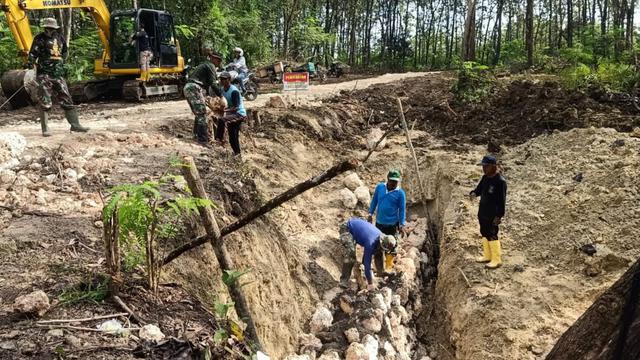 Anggota Satgas TMMD ke-113 Kodim 0721/Blora saat berjibaku bersama warga membangun talud. (Liputan6.com/Ahmad Adirin)