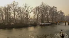 Tukang perahu menggunakan dayung memecahkan lapisan es di sepanjang bagian dalam Danau Dal pada pagi saat musim dingin di Srinagar (2/1/2023). Periode musim dingin yang keras selama 40 hari yang dikenal sebagai 'Chillai Kalan' memperketat cengkeramannya di Kashmir pada hari Senin karena suhu malam semakin turun. (AFP/Tauseef Mustafa)