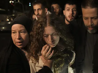 Aktivis Palestina Ahed Tamimi, tengah, disambut oleh ibunya setelah dibebaskan dari penjara oleh Israel, di kota Tepi Barat Ramallah, Kamis (30/11/2023) dini hari. (AP Photo/Nasser Nasser)