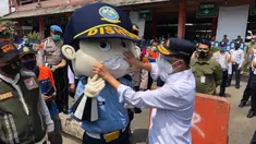 Menteri Perhubungan Budi Karya Sumadi memasangkan masker pada boneka Dishub di Terminal Kampung Rambutan, Jakarta, Kamis (29/10/2020). Budi Karya melakukan edukasi kepada penumpang yang masih banyak menggunakan masker scuba untuk memakai masker medicated atau berlapis. (Dok: Kemenhub)