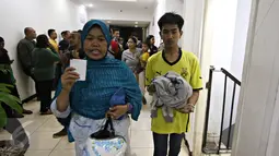 Salah satu orangtua yang datang untuk menjemput anaknya di Polda Metro Jaya, Jakarta, Minggu (18/10). Polisi mengamankan ratusan remaja yang berbuat onar menjelang laga final Piala Presiden di GBK. (Liputan6.com/Immanuel Antonius)