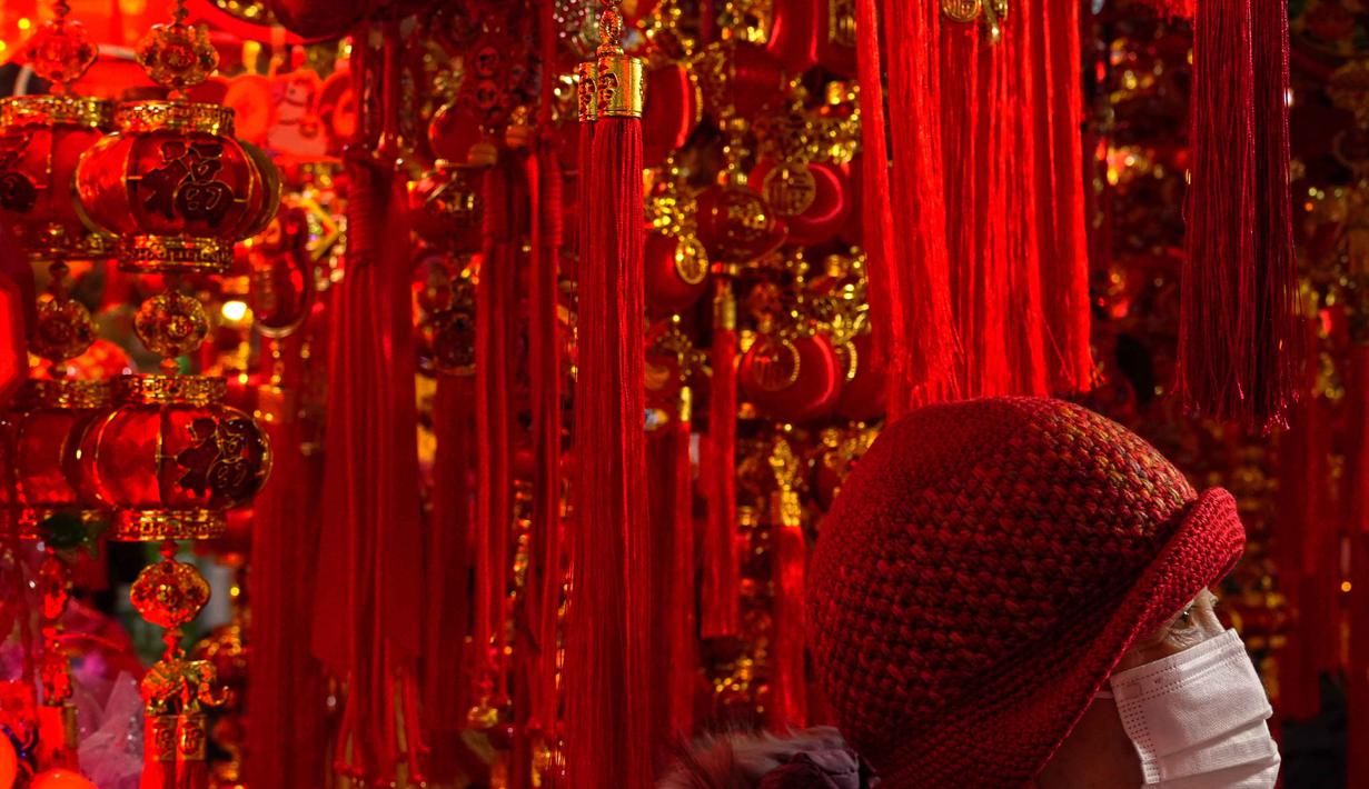 Tahun 2026 adalah Tahun Kuda Api (Fire Horse) yang melambangkan energi yang dinamis, kebebasan, dan semangat perubahan yang kuat. Tampak dalam foto, seorang wanita berbelanja dekorasi keberkahan saat bazar menyambut Tahun Baru Imlek di Beijing, China, Minggu 1 Februari 2026. (AP Photo/Andy Wong)