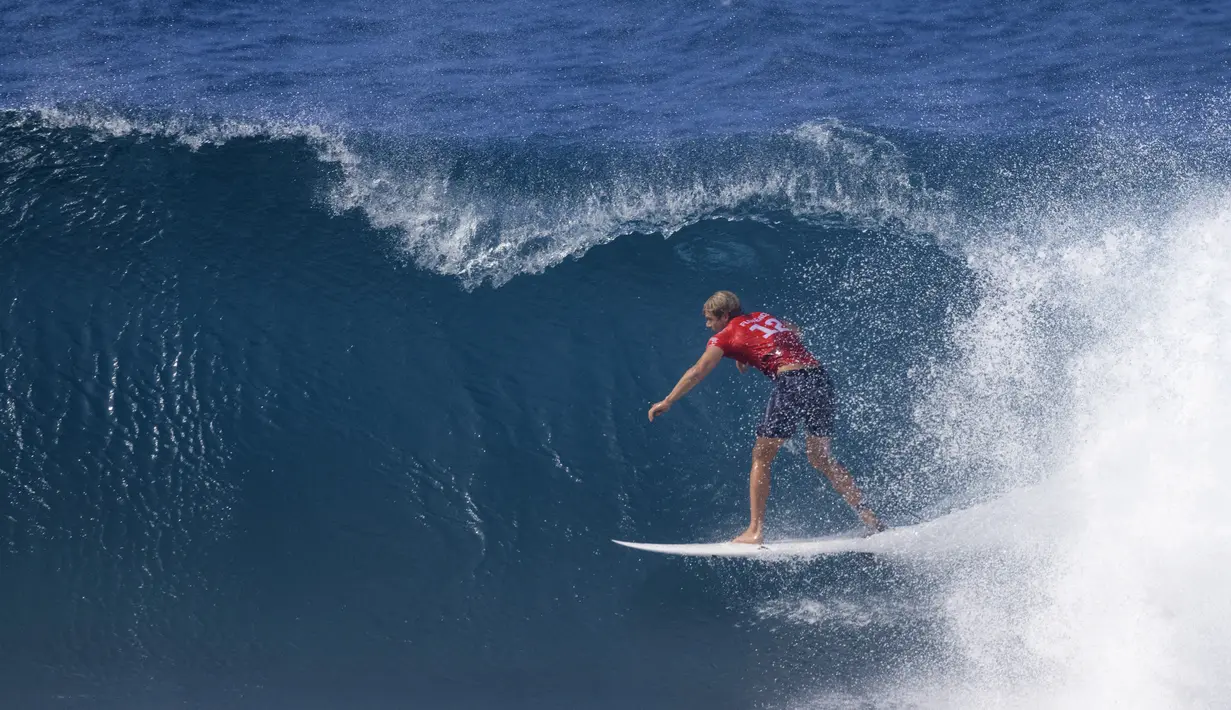 Peselancar Hawaii John John Florence mengendarai ombak pada hari pertama Billabong Pipeline Pro di Banzai Pipeline di pantai utara Oahu, Hawaii, pada 1 Februari 2023. Kejuaraan ini berlangsung dari 29 Januari hingga 10 Februari 2023. (AFP/Brian Bielmann)