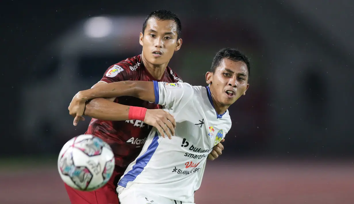 Pemain PSIM Yogyakarta, Nanda Nurrandi (kanan) berebut bola dengan pemain Persis Solo, Eriyanto saat matchday ke-8 Grup C Liga 2 2021 antara Persis Solo melawan PSIM Yogyakarta di Stadion Manahan, Solo, Senin (15/11/2021). (Bola.com/Bagaskara Lazuardi)