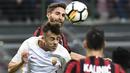 Gelandang AC Milan, Hakan Calhanoglu, duel udara dengan gelandang AS Roma, Stephen El Shaarawy, pada laga Serie A Italia di Stadion San Siro, Milan, Minggu (1/10/2017). Milan kalah 0-2 dari Roma. (AFP/Miguel Medina)