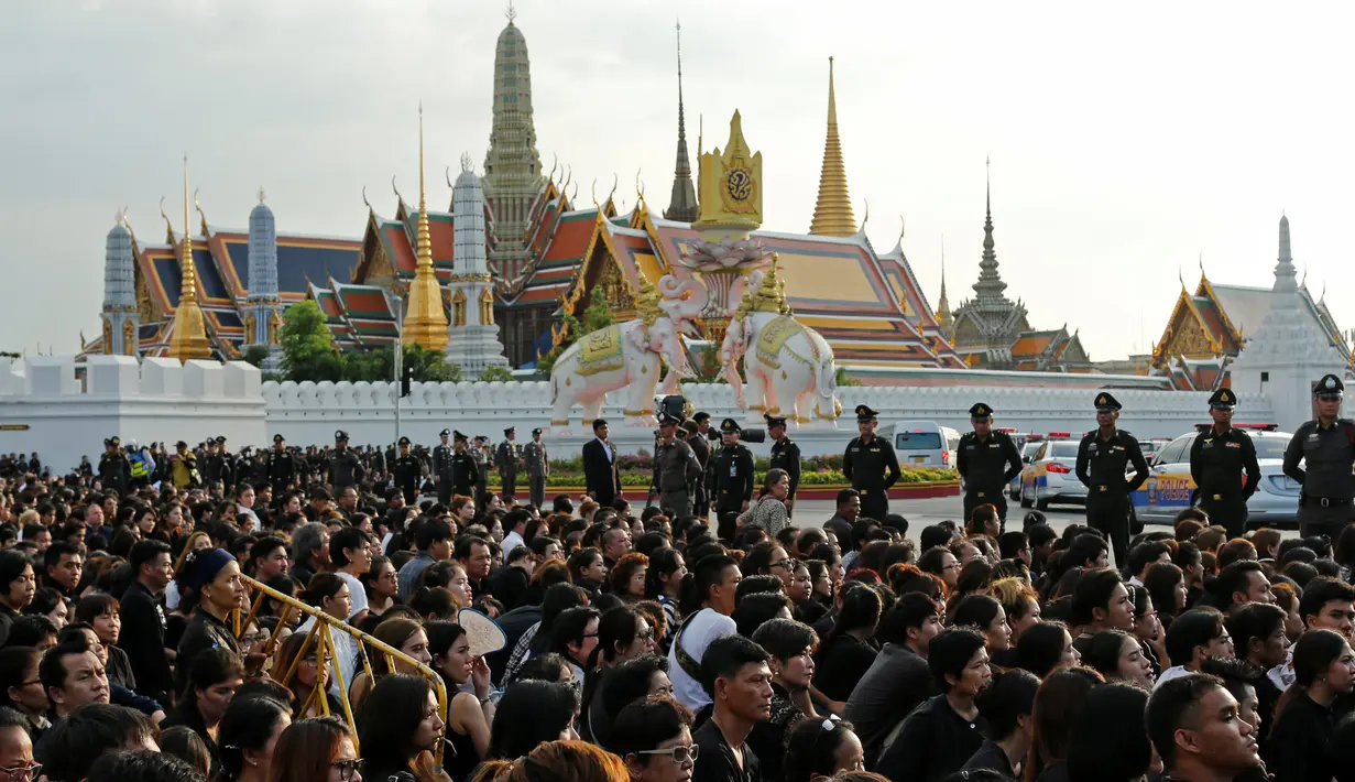 Rakyat Thailand menunggu kedatangan mobil jenazah Raja Thailand Bhumibol Adulyadej di depan Grand Palace, Bangkok, Thailand, Jumat (14/10). (REUTERS / Jorge Silva)
