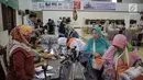 Panitia Penyelenggara Ibadah Haji (PPIH) memberikan perlengkapan untuk calon jemaah haji kloter pertama di Asrama Haji, Jakarta, Sabtu (6/7/2019). Pengecekan kelengkapan administrasi berupa cek kesehatan, foto biometrik dan sidik jari untuk keperluan imigrasi di embarkasi. (Liputan6.com/Faizal Fanan