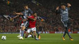 Striker Manchester United, Marcus Rashford, terjatuh saat berebut bola dengan bek Benfica, Eliseu, pada laga Liga Champions di Stadion Old Trafford, Selasa (31/10/2017). Manchester United menang  2-0 atas Benfica. (AP/Dave Thompson)