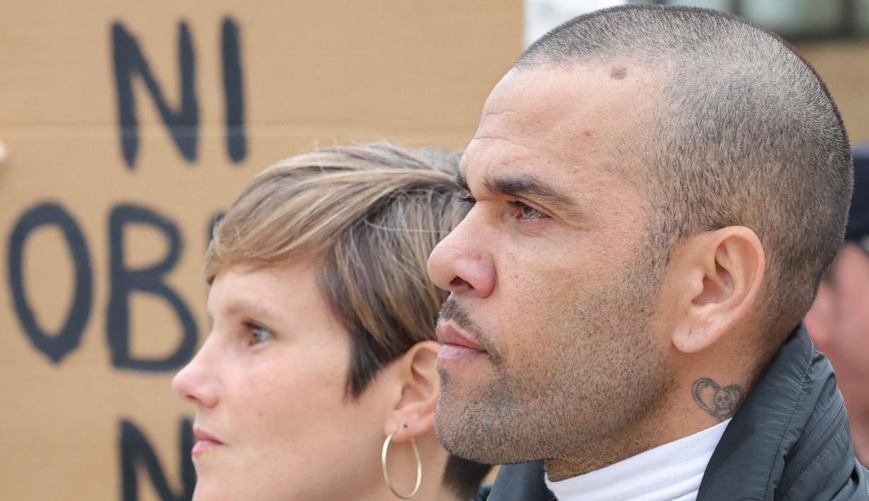Pemain Brasil, Dani Alves (kanan) bersama pengacaranya, Ines Guardiola berjalan meninggalkan penjara Brians 2 di San Esteban Sasroviras, Barcelona, Spanyol, 25 Maret 2024. Alves bebas dari penjara setelah membayar uang jaminan 1 juta euro ke Pengadilan Barcelona. (AFP/Lluis Gene)
