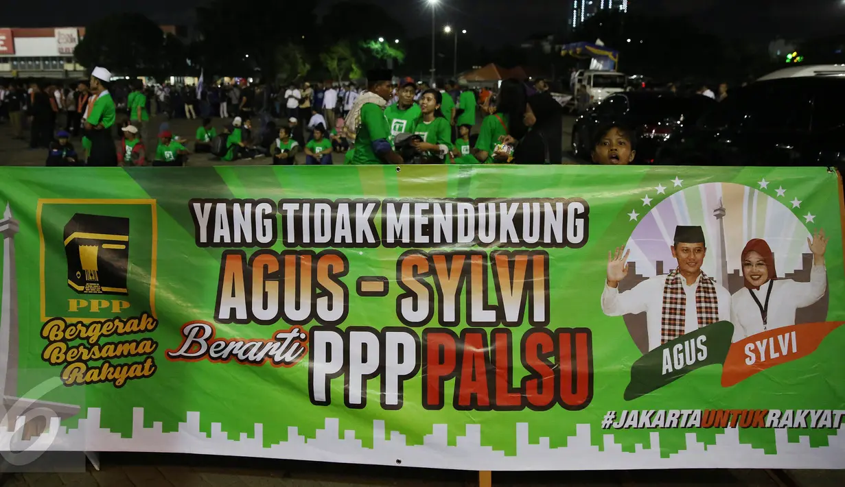 Simpatisan pasangan Agus-Slyvi membentangkan spanduk di Jakarta, Selasa (25/10). Pada hari ini KPUD menggelar acara pengambilan nomer urut Cagub dan Wagub serta Penyerahan Keputusan tentang penetapan nomer urut pasangan. (Liputan6.com/Johan Tallo)