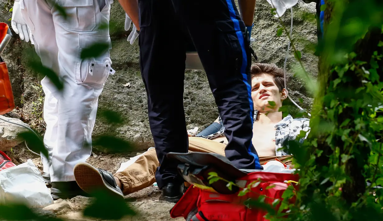 Seorang pemuda yang terluka parah menerima bantuan medis setelah mengalami luka akibat ledakan di Central Park, New York, Minggu (3/7). Kaki kirinya hampir putus akibat ledakan yang masih diselidiki sumber penyebabnya. (Kena Betancur/AFP)