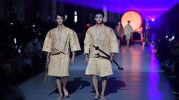 Dua model memeragakan kreasi busana yang terbuat dari brokat Li, pakaian tradisional yang dibuat oleh kelompok etnis Li, dalam sebuah peragaan busana di Haikou, Provinsi Hainan, China selatan, pada 19 November 2020. (Xinhua/Guo Cheng)