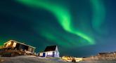 Aurora Borealis menerangi langit malam di atas rumah-rumah penduduk di Nuuk, Greenland, pada 23 Januari 2026. Cahaya hijau bersinar menghiasi langit kota Nuuk, Greenland, pada Jumat 23 Januari 2026 waktu setempat. (Jonathan NACKSTRAND/AFP)