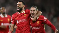 Pemain Liverpool Mohamed Salah (kiri) bersama Kostas Tsimikas merayakan gol pada laga matchday 2 League Phase Liga Champions 2024/2025 melawan Bologna di Anfield Stadium, Inggris pada Rabu 2 Oktober 2024 atau Kamis (3/10/2024) dini hari WIB. (Paul ELLIS/AFP)