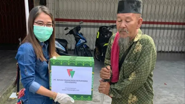 Perwakilan perusahaan di Pekanbaru menyerahkan paket sembako kepada warga terdampak covid-19.
