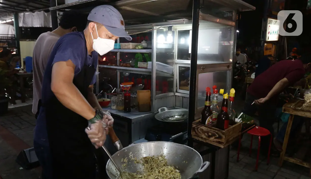 Mantan pegawai fungsional Biro Hukum KPK, Juliandi Tigor Simanjuntak memasak nasi goreng pesanan pelanggan di Jalan Raya Hankam, Bekasi, Rabu (13/10/2021). Tigor berjualan nasi goreng setelah dipecat KPK bersama 57 rekannya yang tidak lolos tes wawasan kebangsaan. (Liputan6.com/Helmi Fithriansyah)